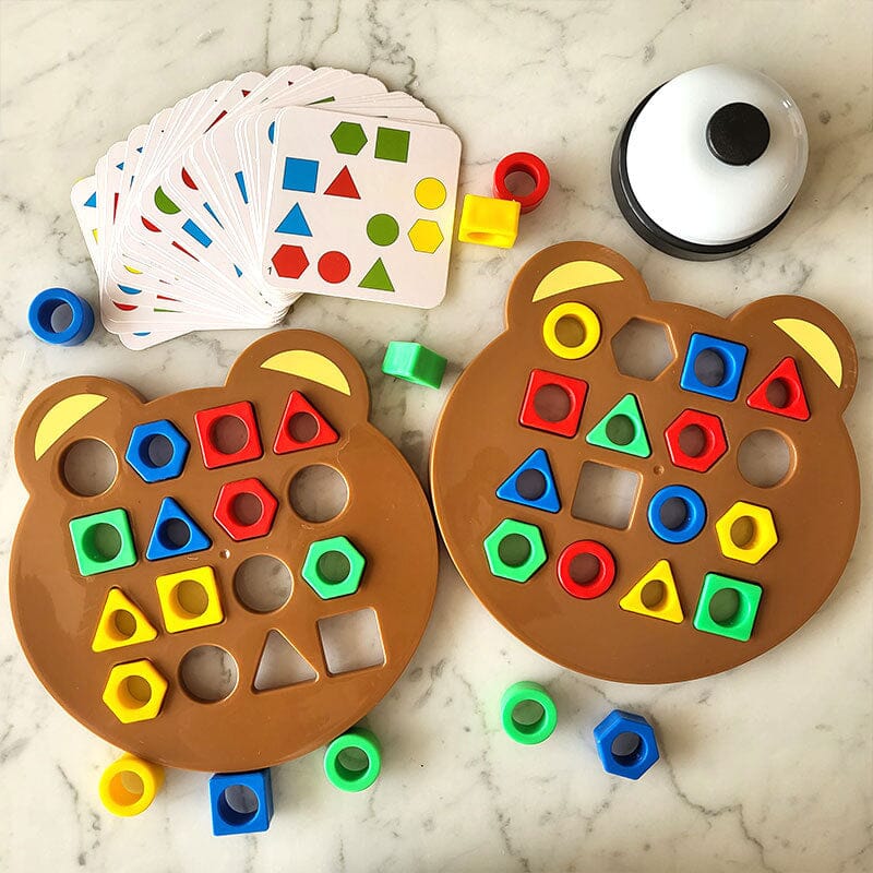 Jeu éducatif pour enfants avec formes géométriques colorées sur plateaux ours, cartes d'activités et sonnette. Apprentissage ludique des formes et couleurs.