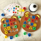 Jeu éducatif pour enfants avec formes géométriques colorées sur plateaux ours, cartes d'activités et sonnette. Apprentissage ludique des formes et couleurs.