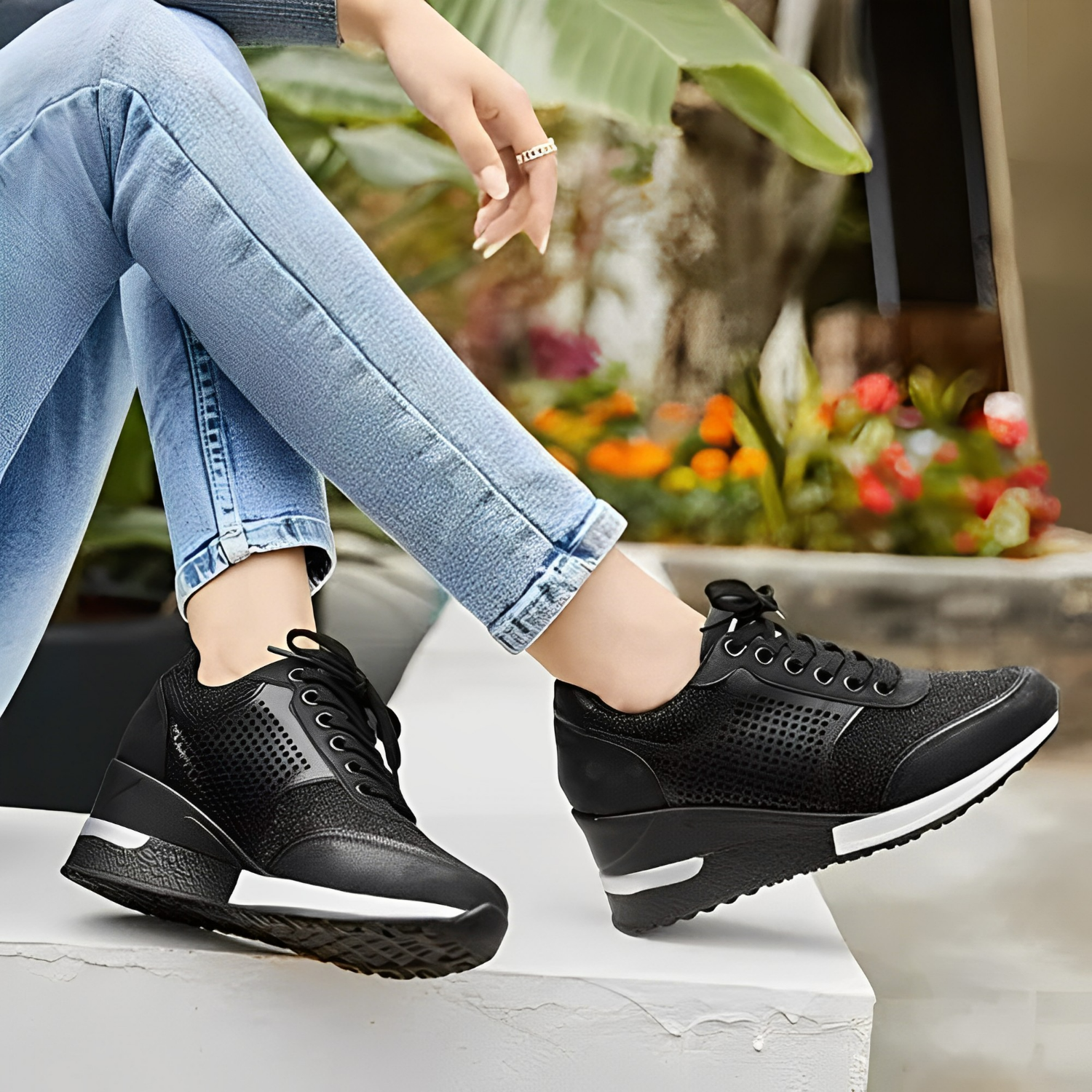 Chaussures compensées noires pour femme, design moderne, portées avec un jean bleu clair. Confort et style, tendance mode urbaine.