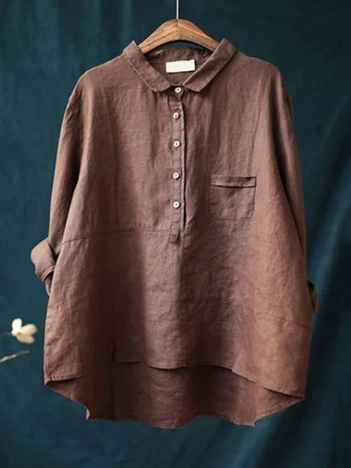 Chemise en lin marron pour femme sur cintre, col boutonné, poche poitrine, fond bleu. Mode éco-responsable, style décontracté, tendance automne.