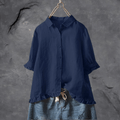 Chemise bleue en lin sur cintre, manches longues retroussées, avec jupe en jean brodée. Mode féminine, vêtements décontractés, style élégant.