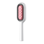 Brosse à cheveux blanche avec coussin rose et picots gris, design ergonomique. Accessoire coiffure moderne, idéal pour démêler et lisser les cheveux.