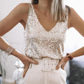 Femme portant un débardeur à paillettes argentées, ceinture blanche et bracelet élégant. Mode chic, tenue de soirée glamour.