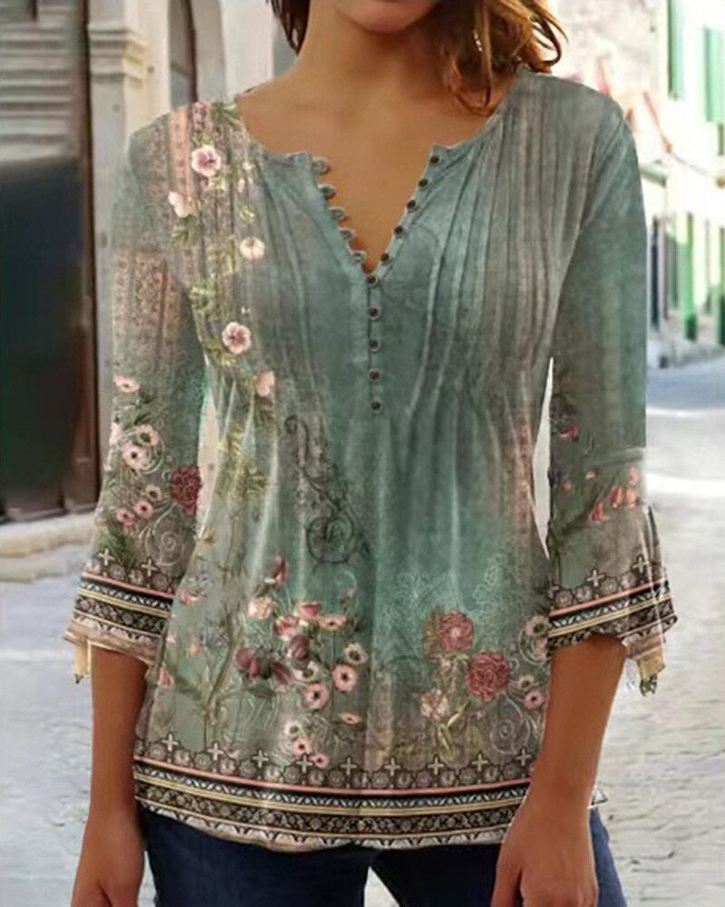Blouse femme bohème chic à manches longues, motif floral, col en V, fond de rue pavée. Mode féminine élégante, tendance automne.