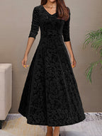 Robe longue noire en velours avec motifs floraux, manches trois-quarts, col en V, élégante et chic, idéale pour soirées ou événements formels.