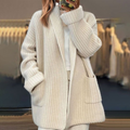 Femme portant un cardigan en maille beige avec poches, style décontracté et élégant, mode automne-hiver, vêtement chaud et confortable.