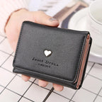 Portefeuille en cuir noir avec un motif de cœur doré, tenu par une main. Accessoire élégant pour femmes, idéal pour organiser cartes et billets.