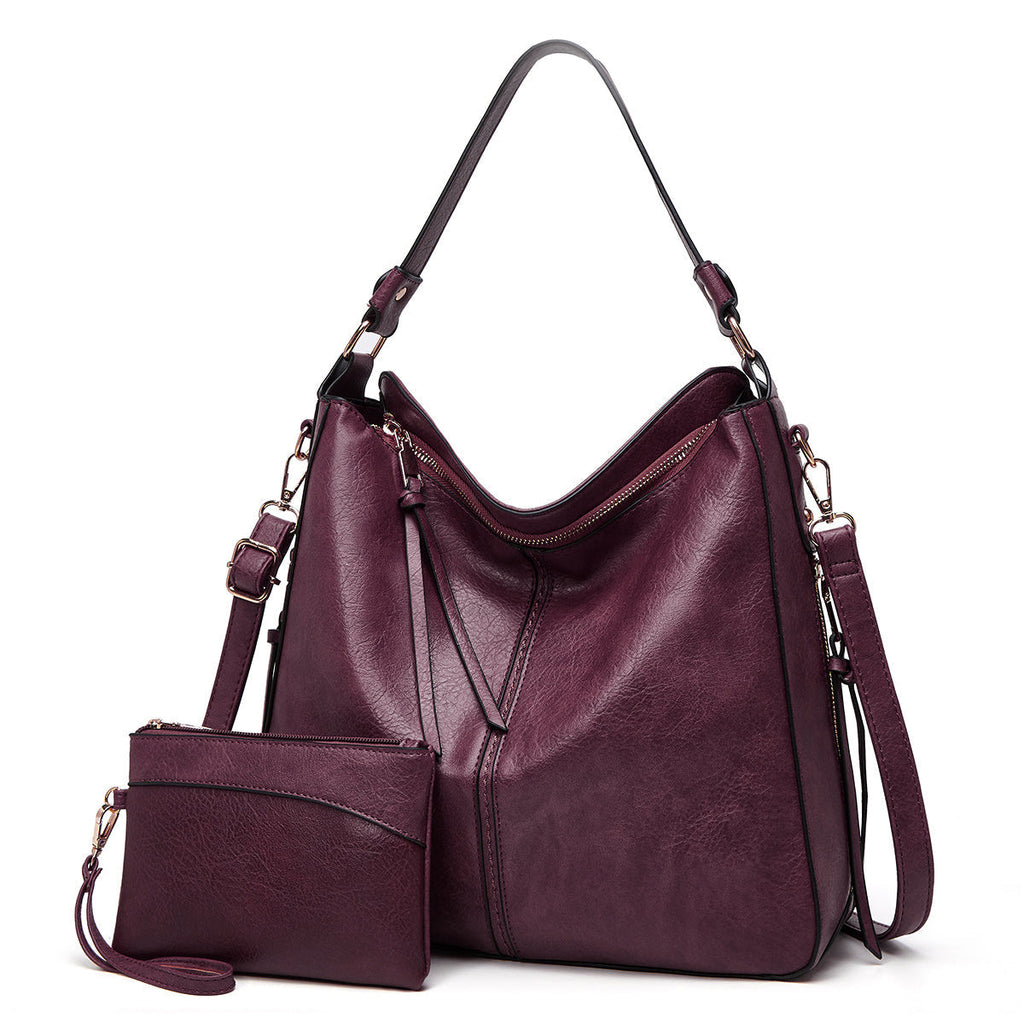 Sac à main en cuir violet avec pochette assortie, bandoulière réglable, design élégant et moderne, idéal pour femme, mode automne-hiver.