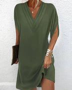 Robe verte élégante à manches courtes, col en V, tenue décontractée pour femme, accessoirisée avec bracelet doré et pochette marron.