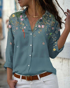 Chemisier bleu à manches longues avec motifs floraux colorés, porté par une femme. Style décontracté, idéal pour la mode féminine printemps-été.