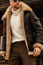 Homme portant un blouson aviateur en cuir marron avec col en fourrure, pull blanc à col roulé, lunettes de soleil, style hivernal élégant.