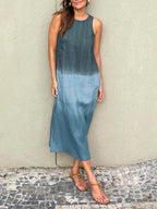 Robe longue dégradée bleue, sans manches, portée par une femme debout sur un sol en mosaïque. Mode estivale, style décontracté, tendance.