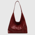 Sac à main en cuir rouge bordeaux, design minimaliste, bandoulière longue, mode femme élégante, accessoire tendance, style moderne.