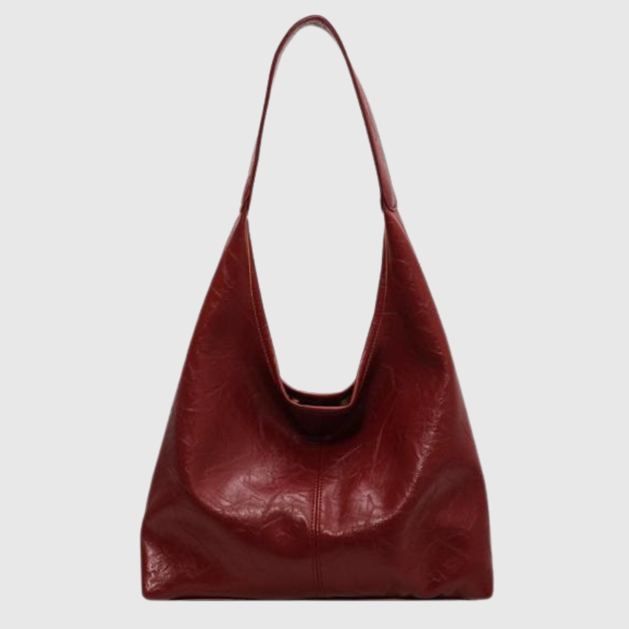 Sac à main en cuir rouge bordeaux, design minimaliste, bandoulière longue, mode femme élégante, accessoire tendance, style moderne.