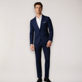 Homme en costume bleu marine élégant, chemise blanche, chaussures noires, pose debout. Mode masculine, tenue formelle, style classique.