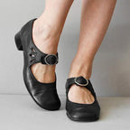 Chaussures noires en cuir pour femme avec boucle argentée, talon bas et découpes décoratives, idéales pour un style élégant et confortable.