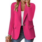 Femme portant un blazer rose vif, chemise blanche et jean, accessoirisée de bijoux dorés. Mode élégante, tenue chic, style moderne.