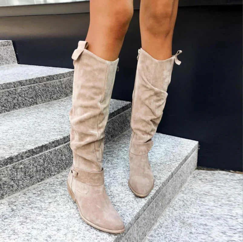 Bottes hautes en daim beige sur escaliers en pierre, mode automne, style décontracté, chaussures femme tendance, look urbain chic.