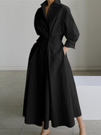 Robe noire élégante longue avec manches longues et col chemise, style minimaliste, mode féminine moderne, tenue chic pour soirée ou événement formel.