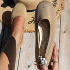 Chaussure beige en tricot avec décoration perles, posée sur un chapeau de paille. Mode estivale élégante, confort et style décontracté.