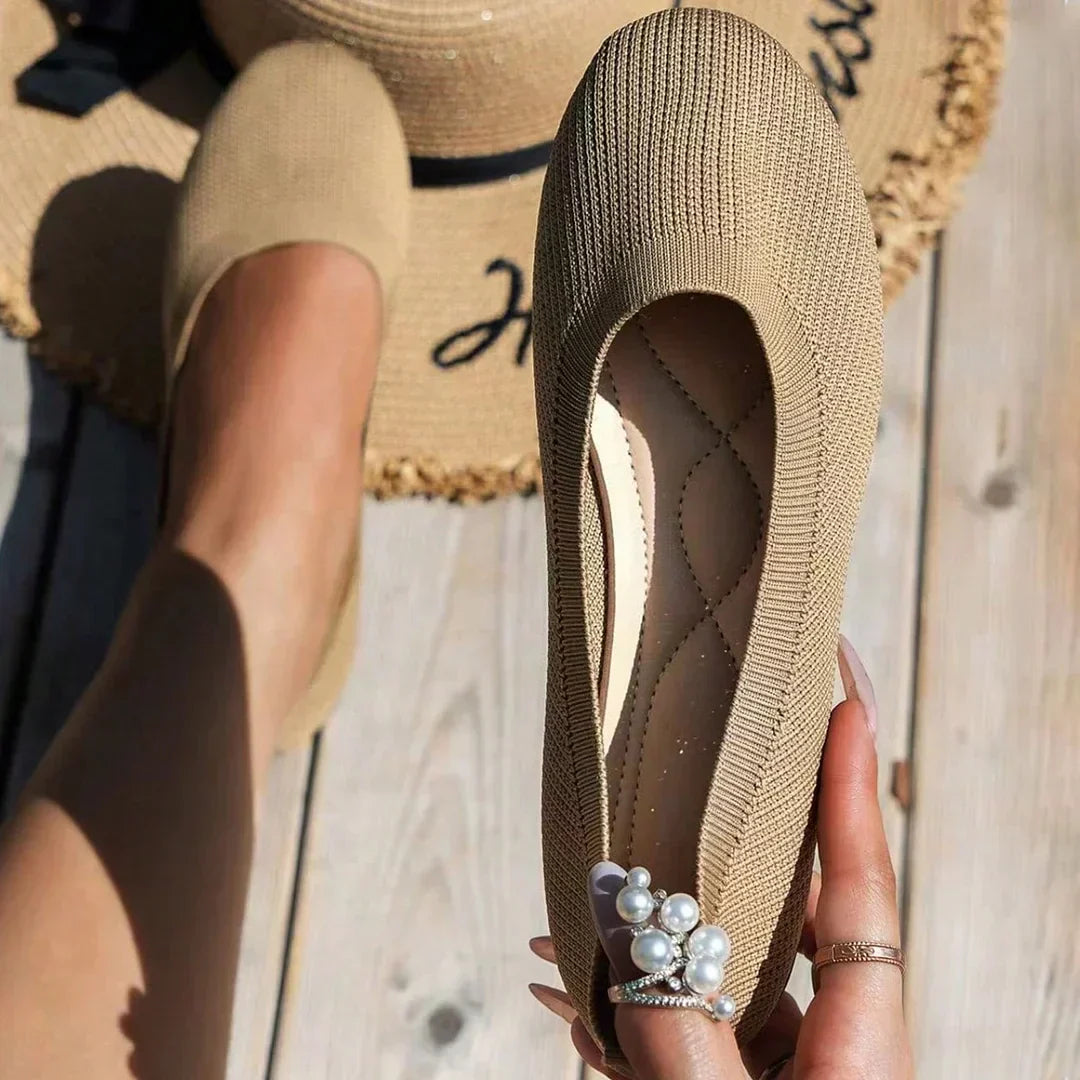 Chaussure beige en tricot avec décoration perles, posée sur un chapeau de paille. Mode estivale élégante, confort et style décontracté.