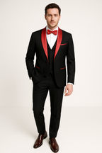 Homme en costume noir avec col et nœud papillon rouges, chemise blanche, chaussures marron. Tenue élégante pour mariage ou soirée formelle.