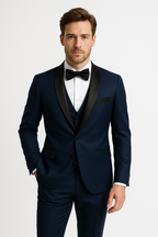 Homme en costume bleu marine élégant avec nœud papillon noir, chemise blanche, posant sur fond blanc. Mode masculine, tenue de soirée chic.