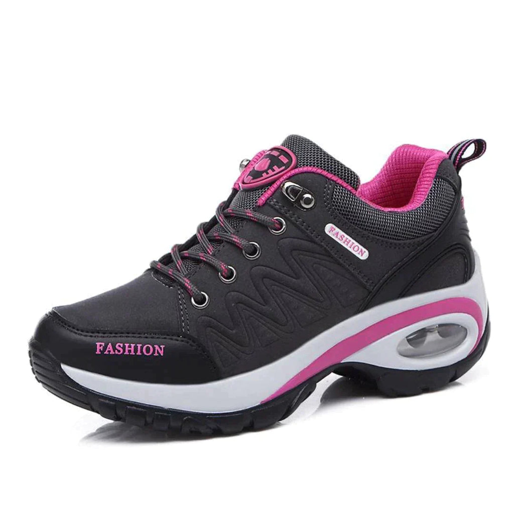Chaussure de sport noire et rose pour femme, semelle épaisse, design moderne, lacets noirs, détails roses, idéale pour fitness et marche.