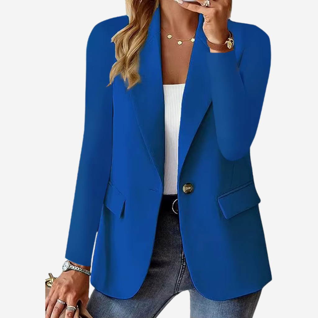 Femme portant un blazer bleu élégant, chemise blanche, jean décontracté, accessoires dorés. Mode féminine chic, tenue professionnelle moderne.