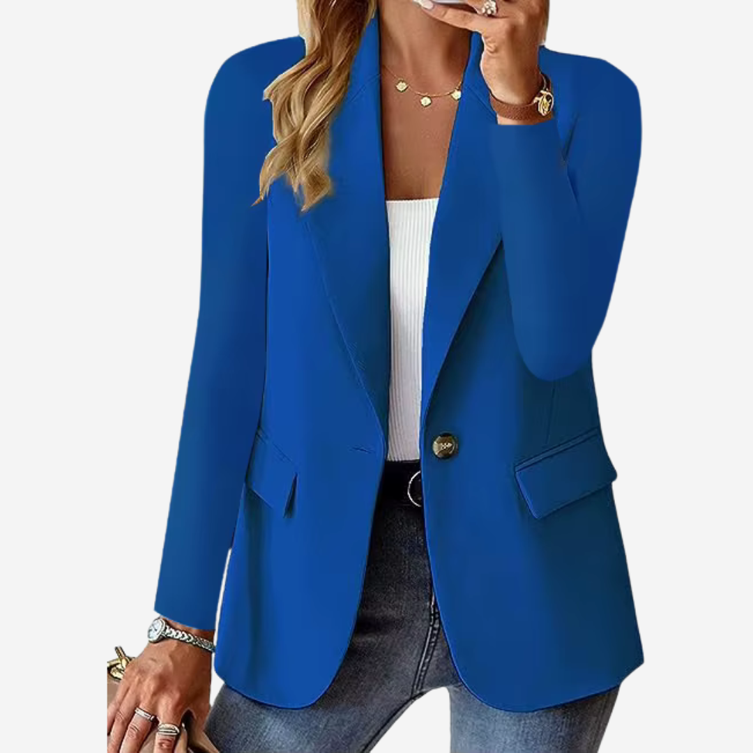 Femme portant un blazer bleu élégant, chemise blanche, jean décontracté, accessoires dorés. Mode féminine chic, tenue professionnelle moderne.