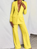 Costume pantalon femme jaune vif, blazer à un bouton, style élégant et moderne, mode féminine tendance, fond blanc.