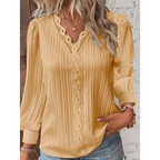 Blouse jaune à manches longues avec dentelle, portée par une femme aux cheveux blonds ondulés, associée à un collier étoile et un bracelet.
