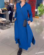 Robe longue bleue élégante avec poches, portée par une femme dans une boutique moderne. Mode féminine, style décontracté, accessoires noirs.