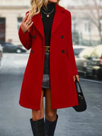 Femme en manteau rouge élégant, jupe noire, col roulé, sac à main noir, rue urbaine. Mode automne-hiver, style chic, tendance féminine.