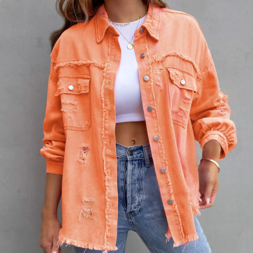 Veste en jean orange délavée pour femme, style décontracté, avec poches et boutons, portée sur un t-shirt blanc et un jean bleu.