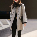 Femme portant un manteau gris élégant, col noir, sac à bandoulière en cuir, tenue chic d'hiver, mode urbaine, style moderne et sophistiqué.