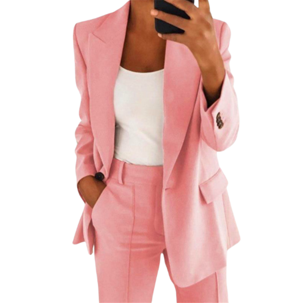 Femme en costume rose élégant, veste et pantalon assortis, tenant un smartphone. Mode féminine, tenue professionnelle chic, style moderne.