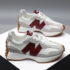 Baskets blanches et grises avec logo rouge, semelle en caoutchouc marron, design moderne. Chaussures de sport tendance pour homme et femme.