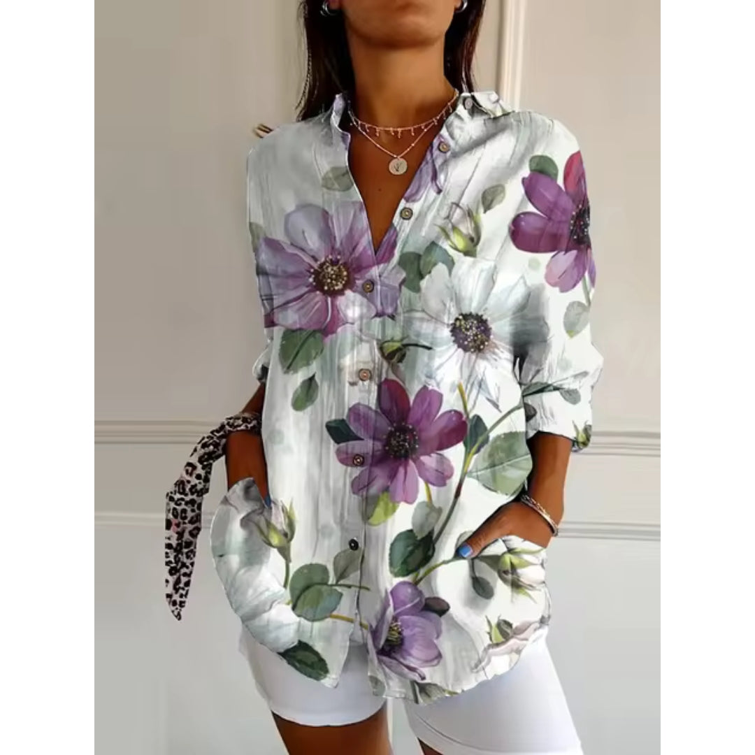 Chemise femme à manches longues avec imprimé floral violet et blanc, col ouvert, portée avec short blanc. Mode élégante et décontractée.