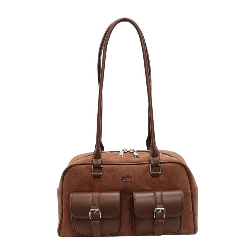 Sac à main en cuir marron avec deux poches avant et longues anses. Élégant et pratique, idéal pour un usage quotidien ou professionnel.