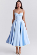 Robe bleue élégante mi-longue avec bretelles fines, décolleté en cœur, jupe évasée, portée par une femme. Mode féminine chic et tendance.