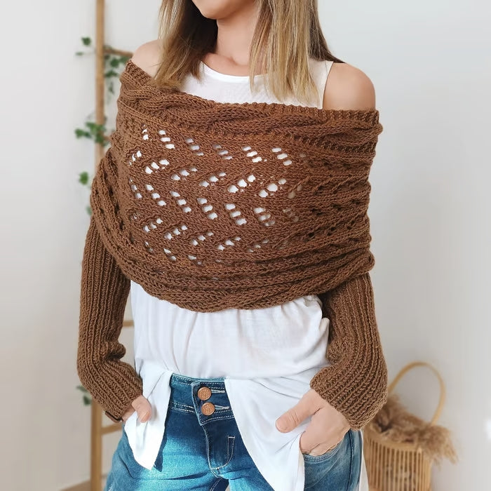 Femme portant un pull tricoté marron ajouré, style bohème, sur un t-shirt blanc. Mode automne, tendance décontractée, manches longues.