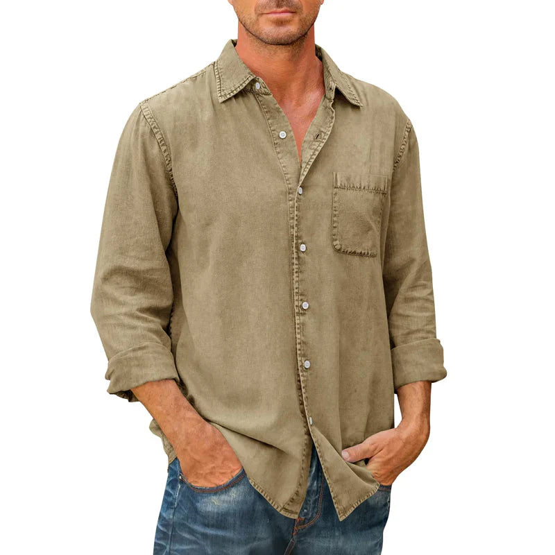 Homme portant une chemise en lin beige avec poche avant, manches retroussées, style décontracté, associée à un jean bleu. Mode masculine élégante.