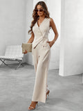 Femme élégante en tailleur beige, lunettes de soleil, tenant une pochette dorée, posant dans un intérieur moderne. Mode chic, tenue professionnelle.