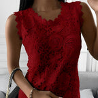 Robe en dentelle rouge élégante avec motifs floraux, portée par une femme. Accessoire: sac à main noir avec chaîne dorée. Mode féminine chic.