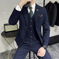 Homme en costume bleu marine élégant, cravate à motifs, montre-bracelet, tenant un smartphone. Style formel, mode masculine, accessoires tendance.