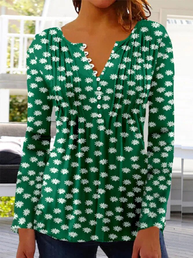 Femme portant un haut vert à manches longues avec motif floral blanc, col en V et boutons. Mode féminine, style décontracté, tendance printemps.
