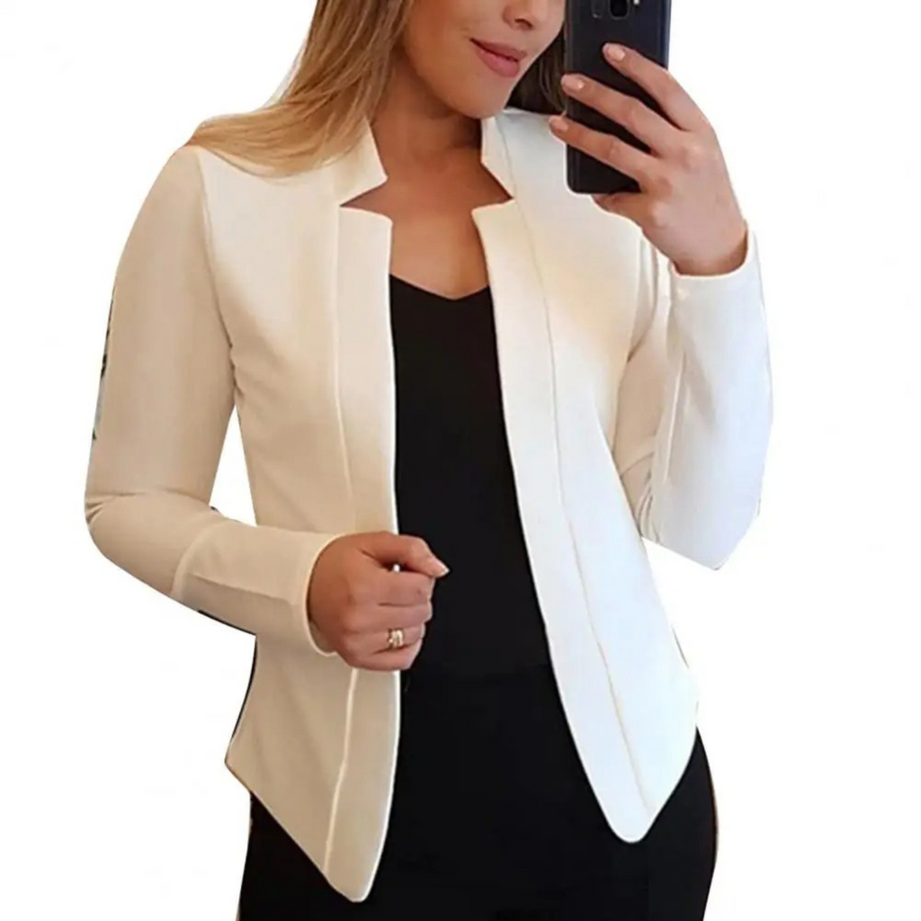 Femme portant un blazer blanc élégant, tenant un smartphone. Mode féminine, tenue professionnelle, style chic et moderne.