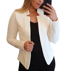 Femme portant un blazer blanc élégant, tenant un smartphone. Mode féminine, tenue professionnelle, style chic et moderne.