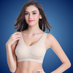 Jeune femme portant un soutien-gorge beige sans couture, fond bleu. Lingerie confortable, mode féminine, sous-vêtements élégants.
